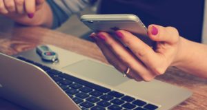 Ragazza con Iphone e Mac al lavoro