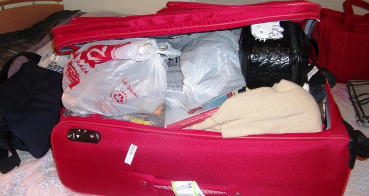 Cosa mettere in valigia: trolley rosso pieno di cose