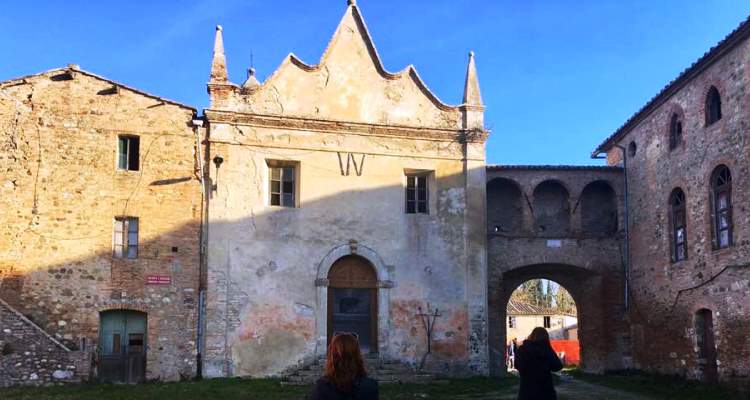 Umbria: due ragazze di spalle di fronte alla chiesa di Salci