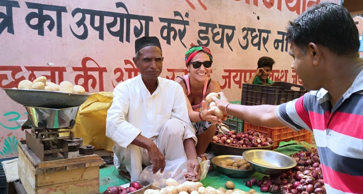 Ragazza seduta accanto a un mercante indiano