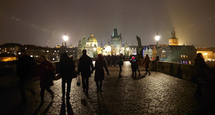 Persone che passeggiano di sera sul ponte Carlo di Praga