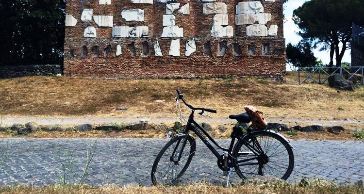 In bici sull'Appia Antica: bicicletta ferma di fronte a un monumento funerario