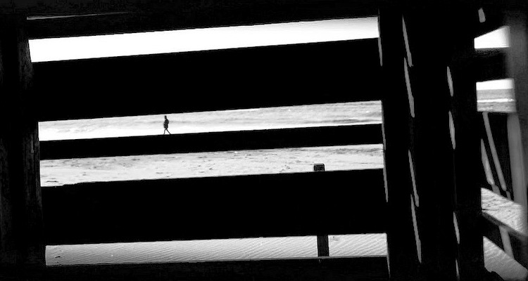 Il mare visto da dietro una grata di legno