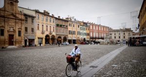 Donna in bicicletta in Piazza del Popolo, a Cesena