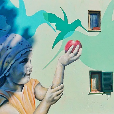 Murale di una bambina con una mela in mano al Trullo