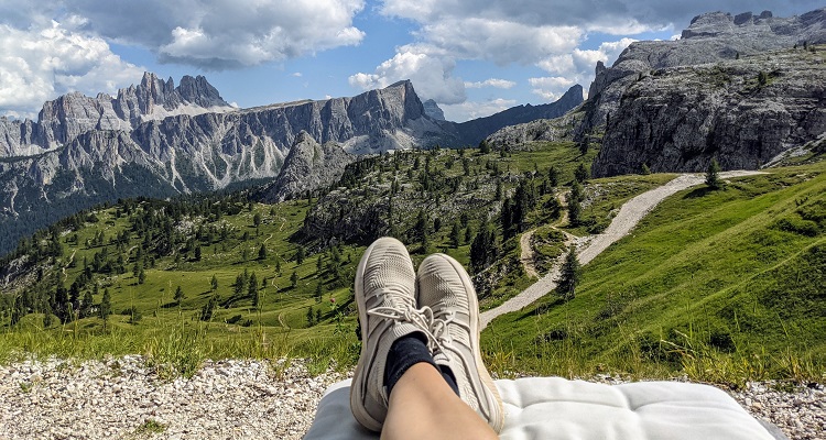 Viaggio sulle Dolomiti: due piedi che sporgono sul panorama di Passo Giau