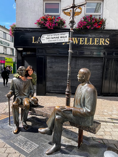 Donna che abbraccia la statua di Oscar Wilde a Galway